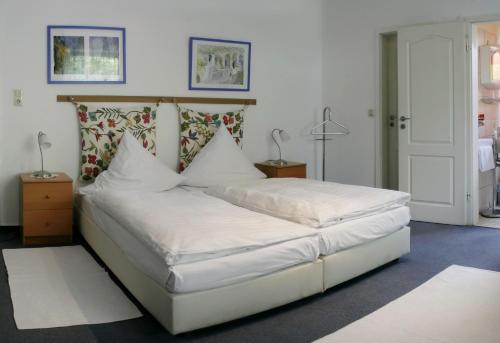 a bed with white sheets and pillows in a bedroom at Hotel Eilenriede in Hannover