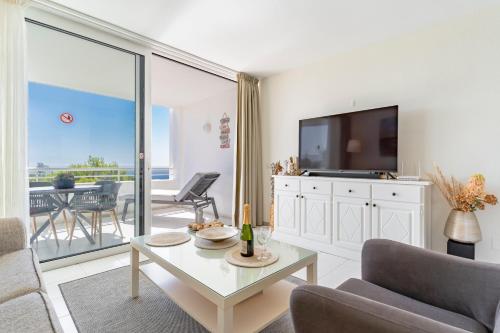 een woonkamer met een tv, een bank en een tafel bij Apartment in Miraflores in Mijas Costa