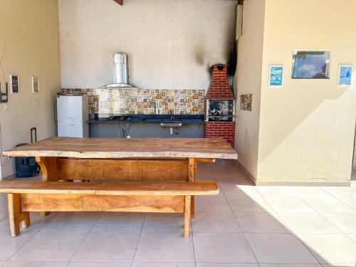 a kitchen with a wooden table and two benches at Barra de Jacuipe Village T in Camaçari