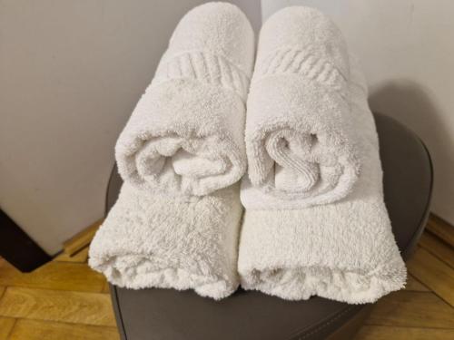 two white towels sitting on top of a chair at Premier House in Tîrgu Ocna
