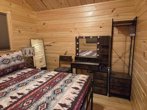 1 dormitorio con 2 camas, tocador y espejo en Flint Rock Cabins - The Spear, en Lonsdale