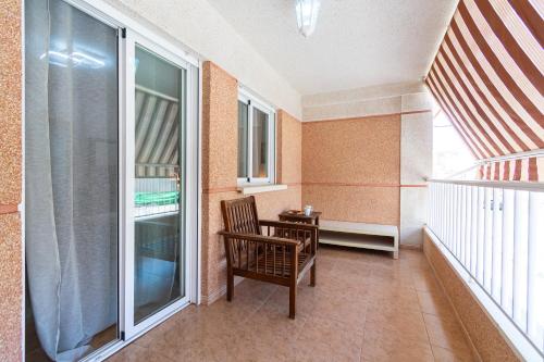 a balcony with a chair and a table and window at Casa Moraira - By Aloha Palma in Águilas