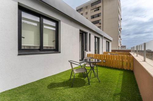 a balcony with a table and chairs on the grass at GuestReady - Tutti Frutti Studios in Porto