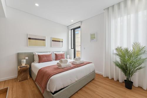 a bedroom with a large bed and a potted plant at GuestReady - Tutti Frutti Studios in Porto
