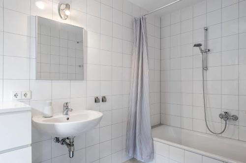 フォグツブルクにあるFerienwohnung Feierabendの洗面台とシャワー付きの白いバスルーム