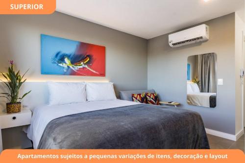 a bedroom with a bed and a painting on the wall at GO Carlos Gomes by My Way in Porto Alegre