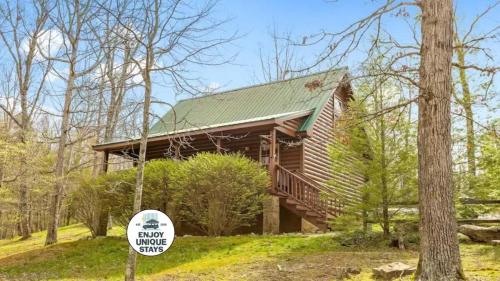 a log cabin in the woods with a sign in front at Scenic Solitude at Cabins in the Clouds in Rising Fawn