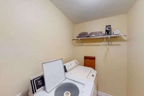 a laundry room with a washing machine and a shelf at Scenic Solitude at Cabins in the Clouds in Rising Fawn