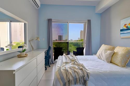 a bedroom with a white bed and a large window at Caribbean Nature Sourrounded Refuge Apartment in Juan Dolio