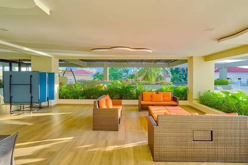 an empty lobby with two couches and orange chairs at Caribbean Nature Sourrounded Refuge Apartment in Juan Dolio