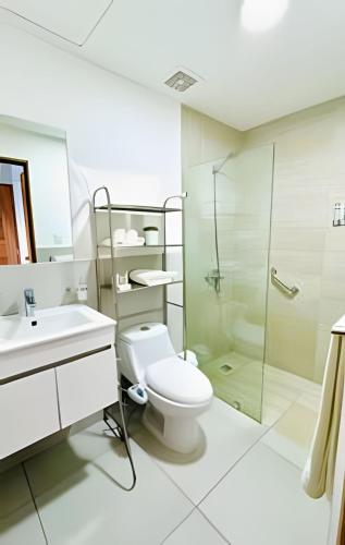 a bathroom with a toilet and a glass shower at Caribbean Nature Sourrounded Refuge Apartment in Juan Dolio