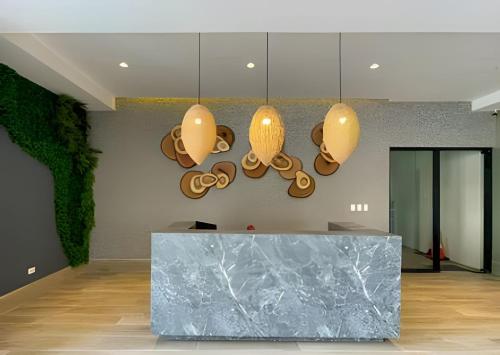 a lobby with a marble counter and three lights at Caribbean Nature Sourrounded Refuge Apartment in Juan Dolio