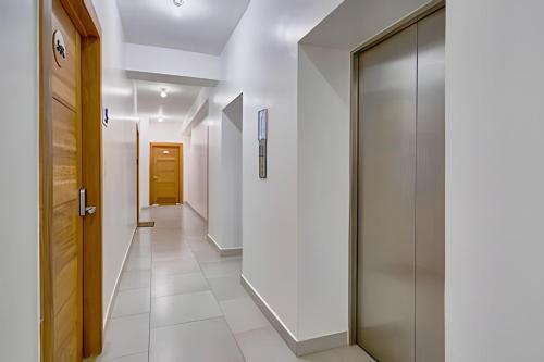 a hallway with white walls and a glass door at Caribbean Nature Sourrounded Refuge Apartment in Juan Dolio
