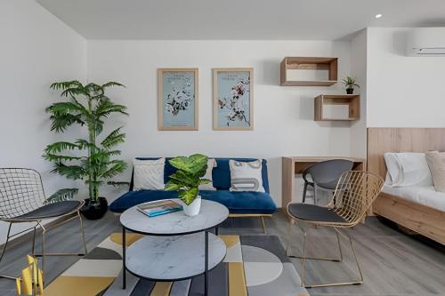 Una sala de estar con un sofá, una mesa y sillas. en Clase 48 apt1002 - Loft with Panoramic Views and AC, en Sabaneta