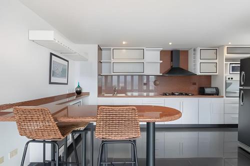 a kitchen with a wooden table and two chairs at Santiago De Bagatela 1104 - Spacious apt Poblado in Envigado