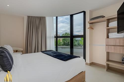 a hotel room with a bed and a window at Solei Loft 401 - Elegance & Comfort /AC in Poblado in El Poblado