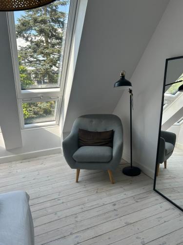 a living room with a chair and a lamp at Tjebberupgaard B&B in Holbæk