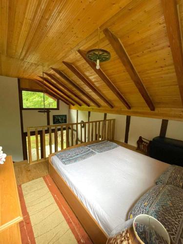 a large bed in a room with a wooden ceiling at UNA Dream in Bihać