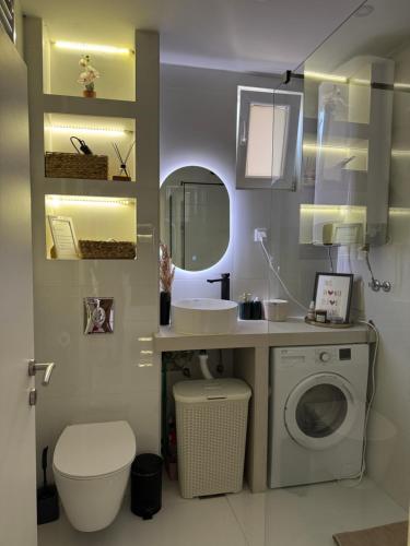 a bathroom with a sink and a washing machine at Central Prestige Apartment in Budva
