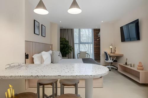 Un dormitorio con una cama y una mesa con sillas. en Solei Loft 303 - Modern Loft in Poblado with AC, en El Poblado