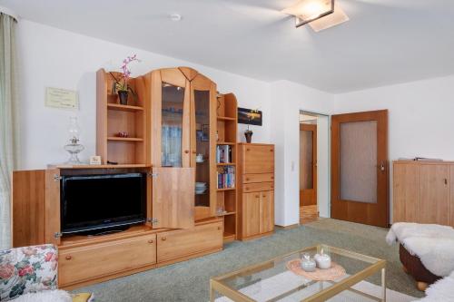 a living room with a large entertainment center with a flat screen tv at Ferienwohnung Veronika Heilbock in Sankt Peter