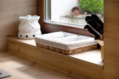 a window sill with a basket and a vase on it at Ferienwohnung Veronika Heilbock in Sankt Peter