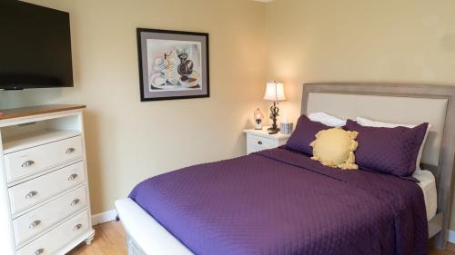 a bedroom with a purple bed with a teddy bear on it at Audubon Acres l pool table & outdoor dining in Benton Harbor