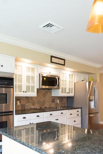 a kitchen with white cabinets and stainless steel appliances at Audubon Acres l pool table & outdoor dining in Benton Harbor