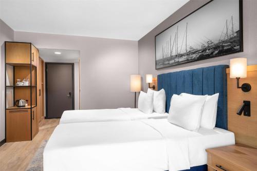 a hotel room with two beds and a painting on the wall at Radisson Blu Resort & Spa Cesme in Cesme