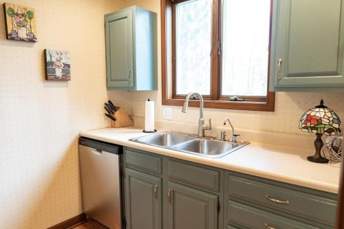 a kitchen with a sink and a window at Audubon Acres l pool table & outdoor dining in Benton Harbor