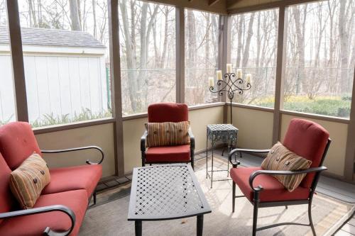 a screened in porch with two chairs and a table at Audubon Acres l pool table & outdoor dining in Benton Harbor