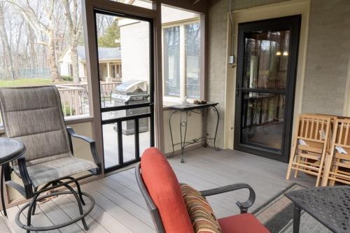 a screened porch with a chair and a table at Audubon Acres l pool table & outdoor dining in Benton Harbor