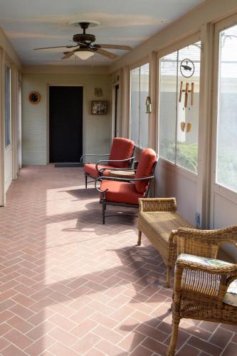 a screened in porch with chairs and a ceiling fan at Audubon Acres l pool table & outdoor dining in Benton Harbor
