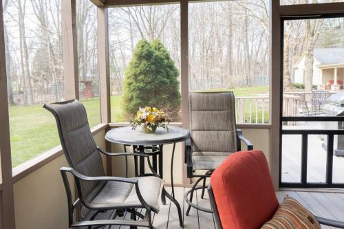 a screened in porch with chairs and a table at Audubon Acres l pool table & outdoor dining in Benton Harbor