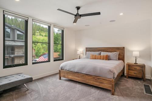 a bedroom with a large bed and windows at 120 Cedar Drive, Slopeside 4BR Townhome with Mountain Views & Hot Tub in Winter Park