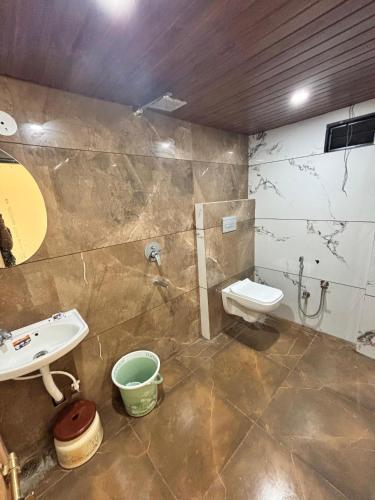 a bathroom with a sink and a toilet at Hotel Shree Balaji in Ujjain