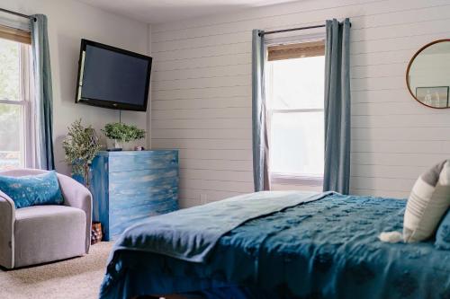 a bedroom with a blue bed and a tv at Kevins Place near PawPaw Lake in Watervliet