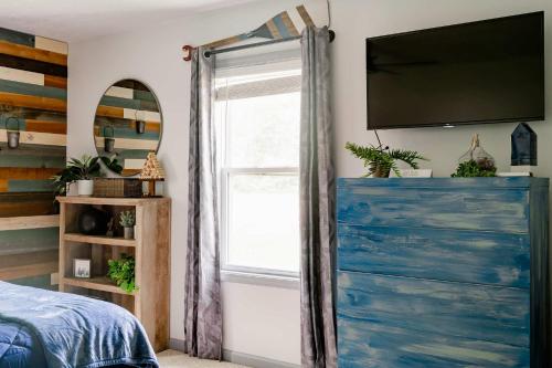 a bedroom with a blue dresser and a window at Kevins Place near PawPaw Lake in Watervliet