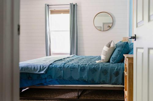 a bedroom with a bed with a blue comforter and a mirror at Kevins Place near PawPaw Lake in Watervliet