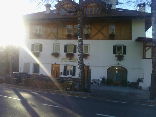 a large white building with the sun shining on it at Agri-park Casa Miramonte in Ronzone