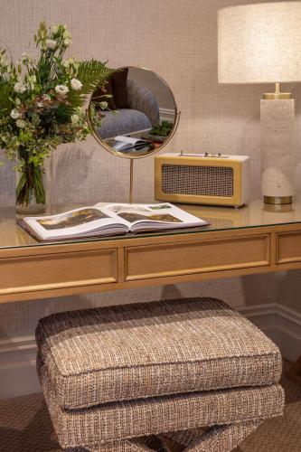 a desk with a table with a mirror and a stool at Killarney Royal Townhouse in Killarney