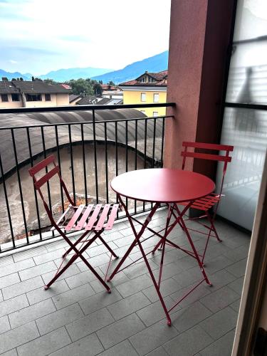 two chairs and a table and a table and chairs on a balcony at Appartamento Il Cigno in Gravedona