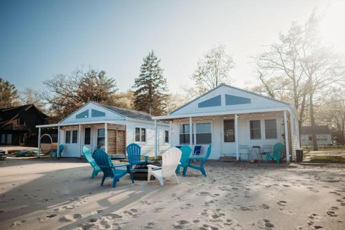 a house with chairs and a table on the beach at 4 Beachfront Cottages - New Bathrooms and Roofs in Lincoln Junction