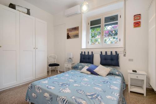 a bedroom with a blue bed and a window at Fiordalisi in Rapallo