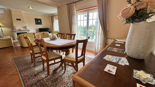 a dining room with a table and chairs and a living room at Toca dos Coelhos in Silveira