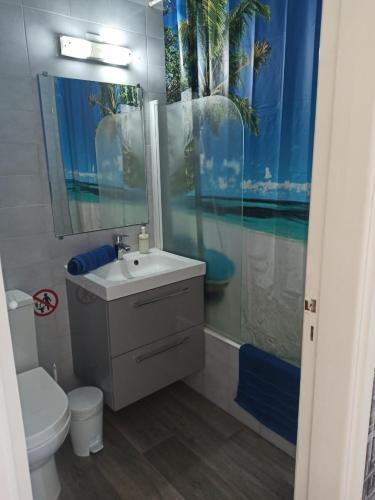 a bathroom with a sink and a toilet and a mirror at Luxuru sea view apt in Pyla
