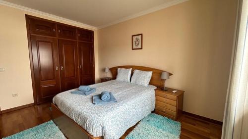 a bedroom with a bed with blue towels on it at Toca dos Coelhos in Silveira