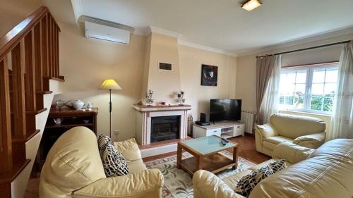 a living room with a couch and a fireplace at Toca dos Coelhos in Silveira