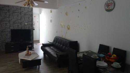 a living room with a black couch and a tv at Luxuru sea view apt in Pyla