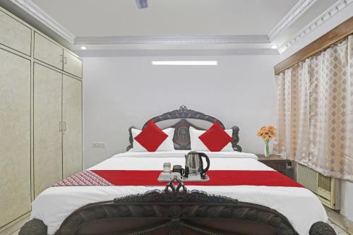 a bedroom with a large bed with red pillows at Super Hotel O Alpine Glow Crest in Hyderabad